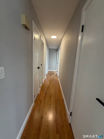 a view of a hallway with wooden floor