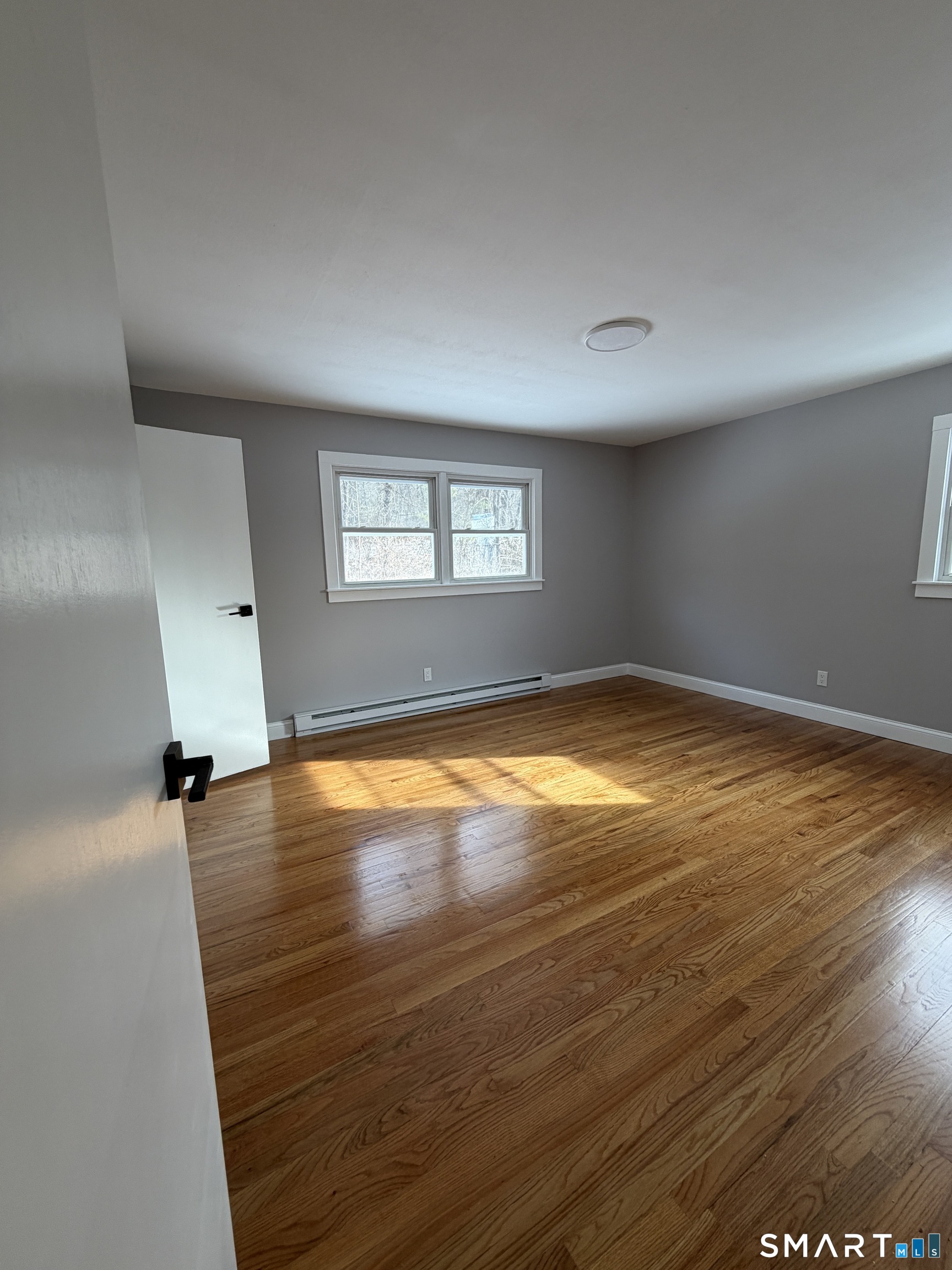 131 Pocono Road Brookfield, CT 06804 - Photo 22 of 27 an empty room with wooden floor and windows