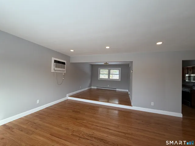 a view of empty room with wooden floor and entryway