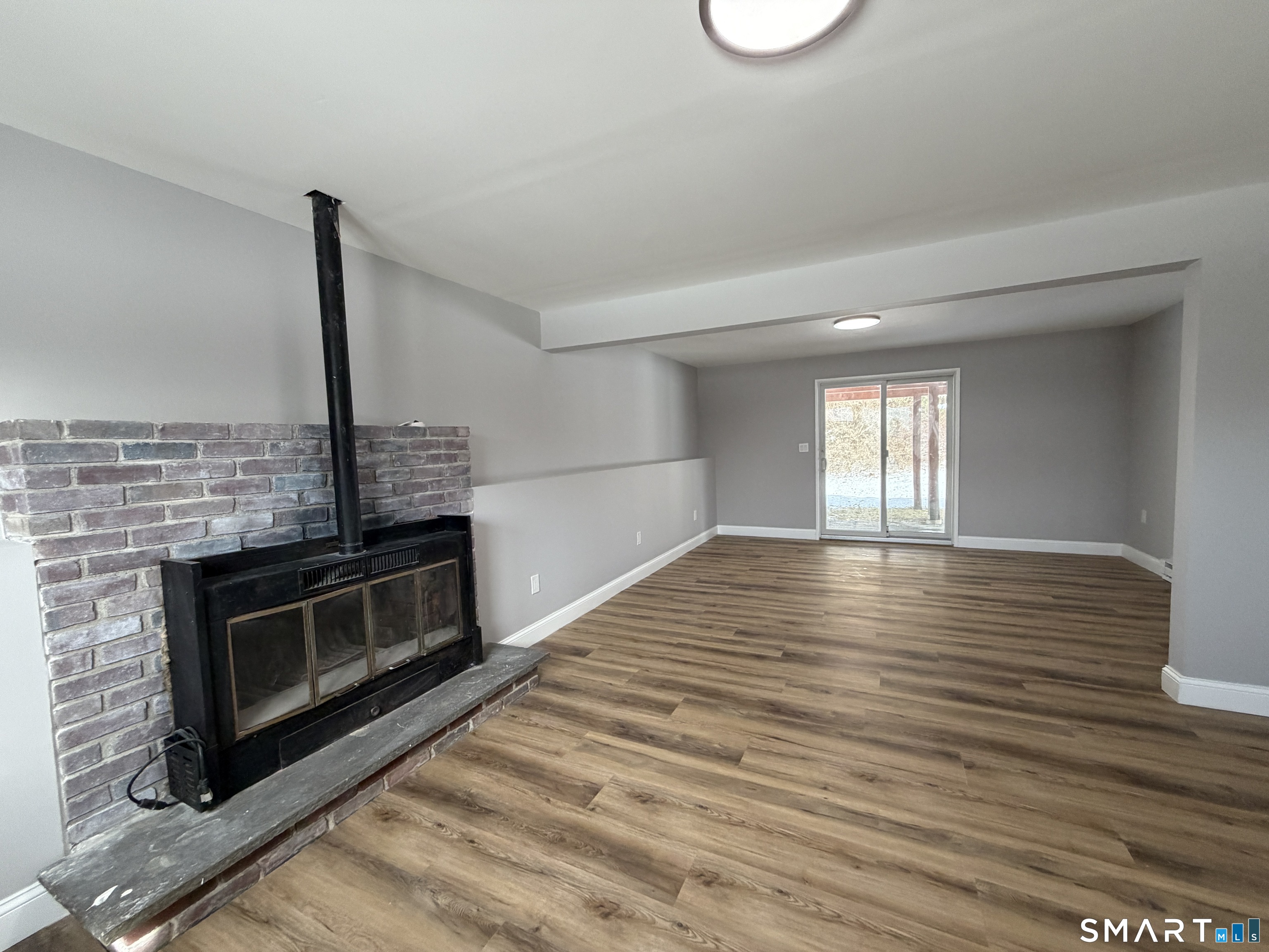 131 Pocono Road Brookfield, CT 06804 - Photo 8 of 27 a view of an empty room with wooden floor and a fireplace