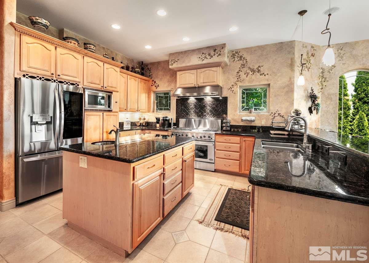 39 Sawbuck Road Reno, NV 89519 - Photo 8 of 23 a kitchen with stainless steel appliances granite countertop a sink a stove and a refrigerator