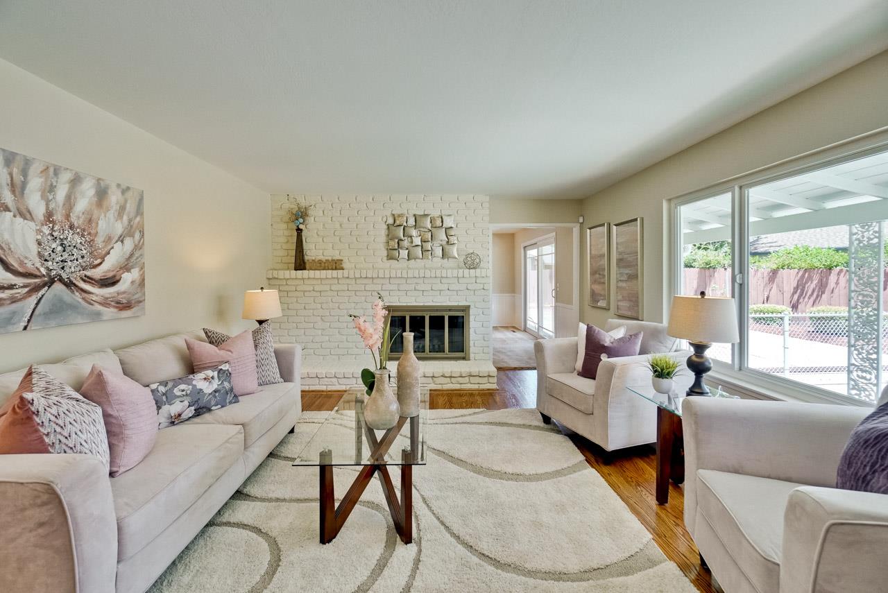 18665 Aspesi Drive Saratoga, CA 95070 - Photo 15 of 39 a living room with furniture large window and a fireplace