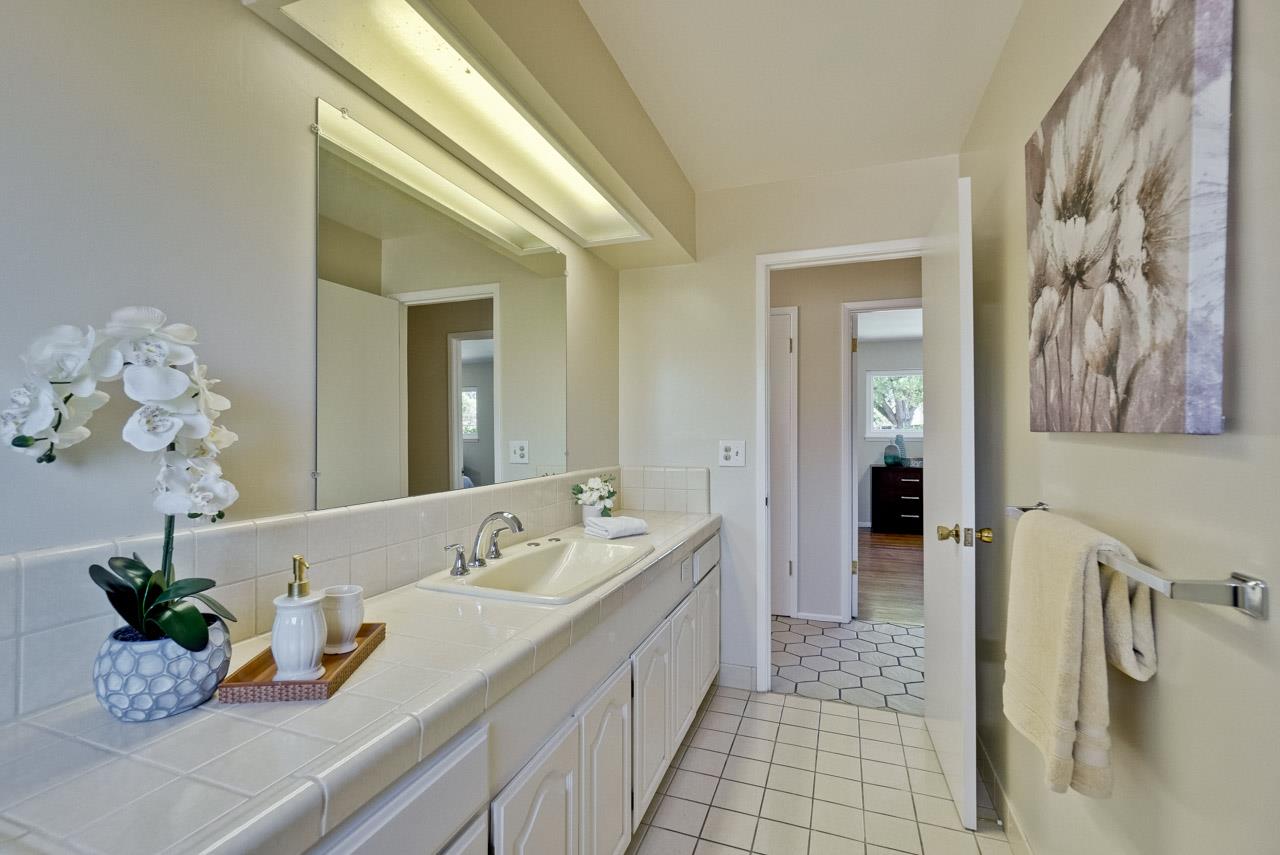 18665 Aspesi Drive Saratoga, CA 95070 - Photo 19 of 39 a bathroom with a sink a faucet and a mirror