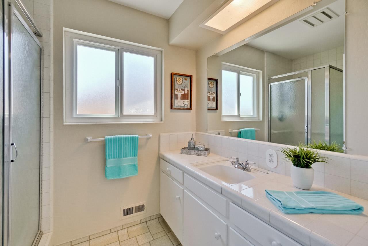 18665 Aspesi Drive Saratoga, CA 95070 - Photo 25 of 39 a bathroom with a granite countertop sink and a mirror