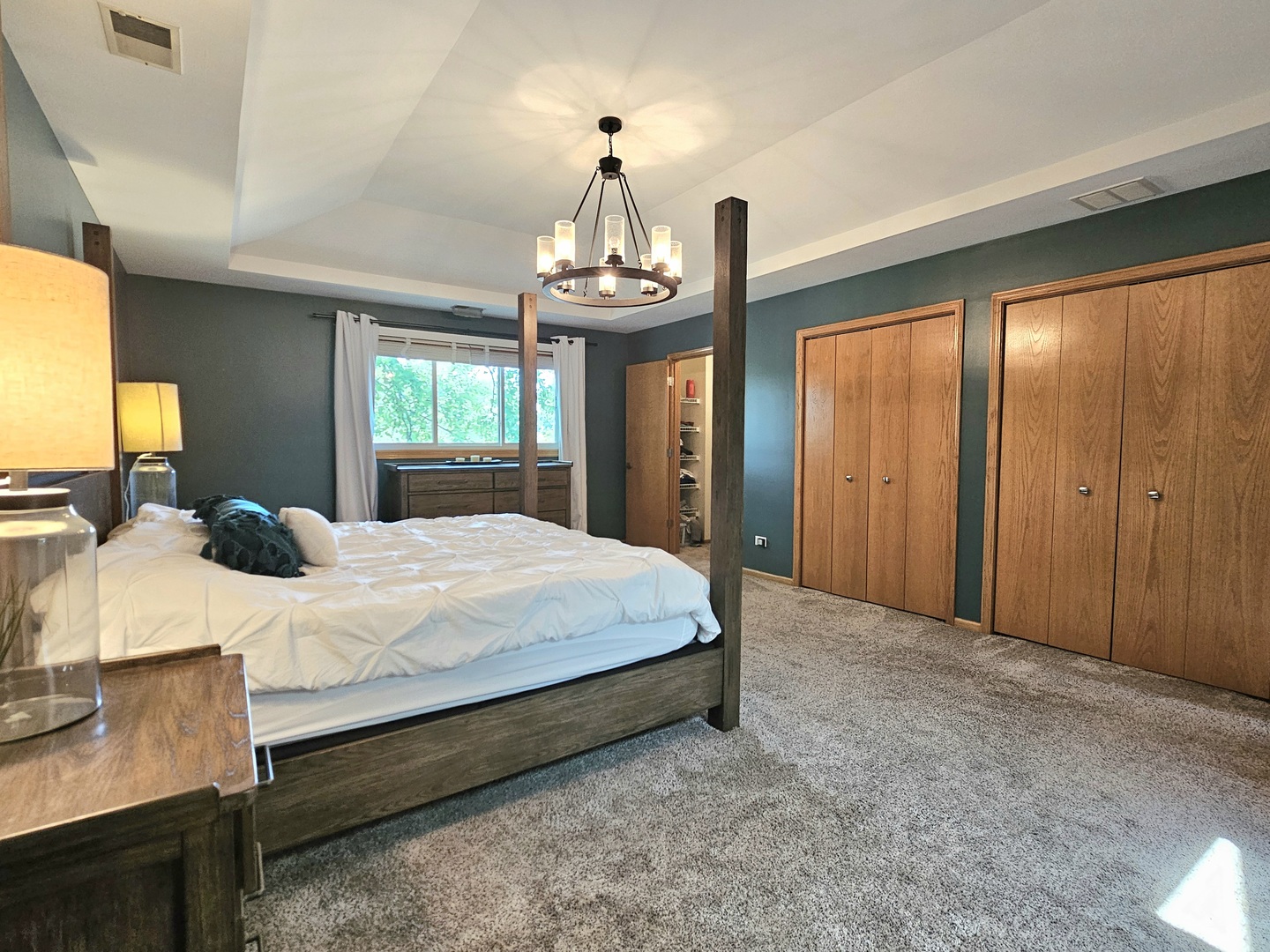 19451 Lancaster Drive Mokena, IL 60448 - Photo 19 of 32 a bedroom with a large bed and a chandelier