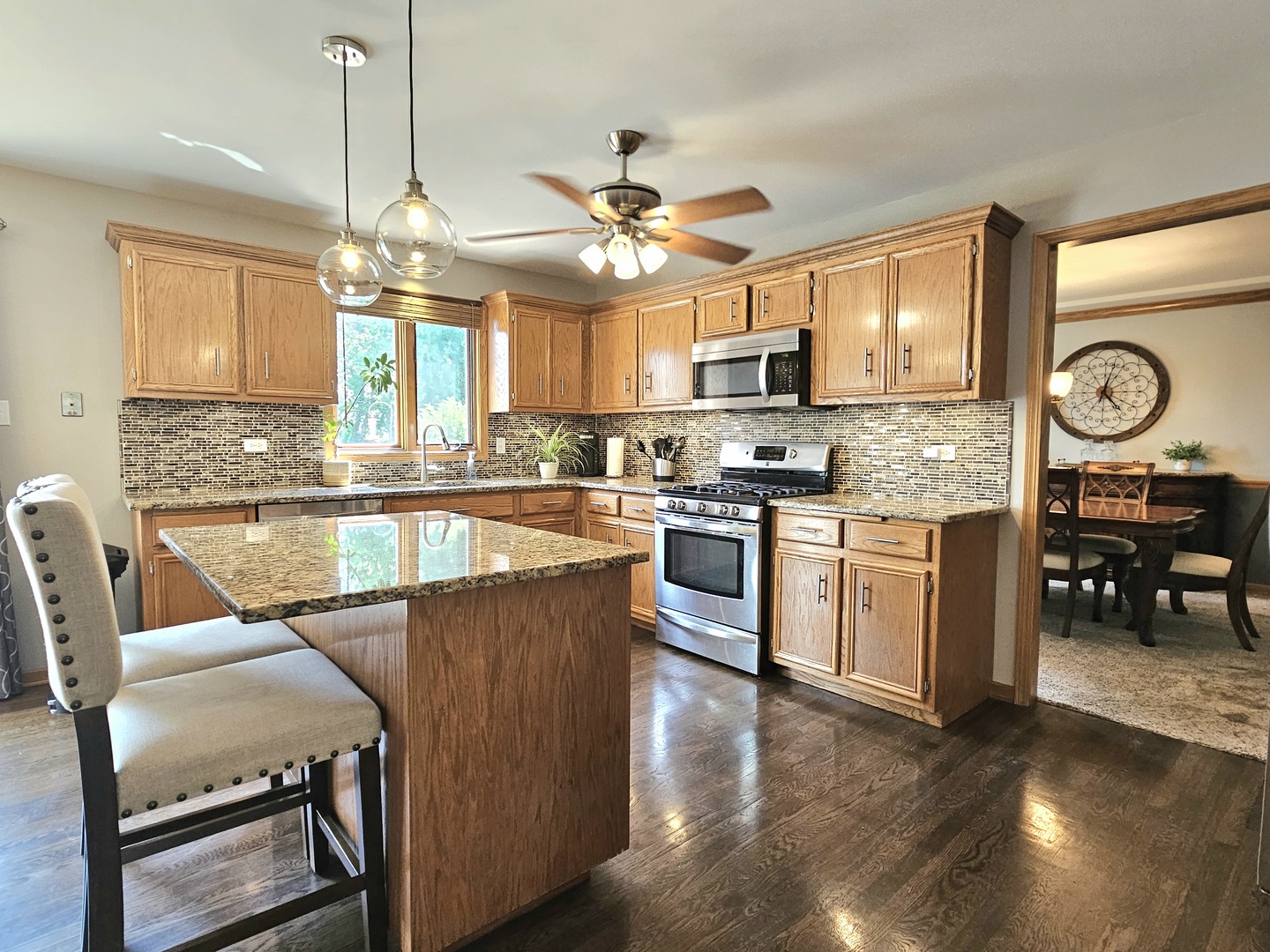 19451 Lancaster Drive Mokena, IL 60448 - Photo 4 of 32 a kitchen with stainless steel appliances granite countertop a stove top oven a refrigerator a sink dishwasher a dining table and chairs with wooden floor