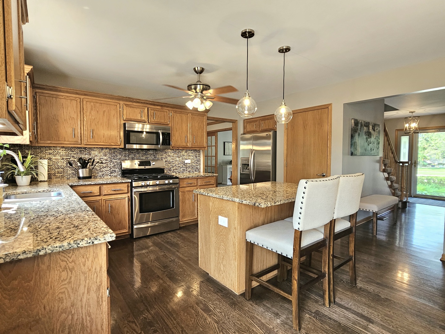 19451 Lancaster Drive Mokena, IL 60448 - Photo 5 of 32 a kitchen with stainless steel appliances granite countertop a stove top oven a sink dishwasher a dining table and chairs with wooden floor