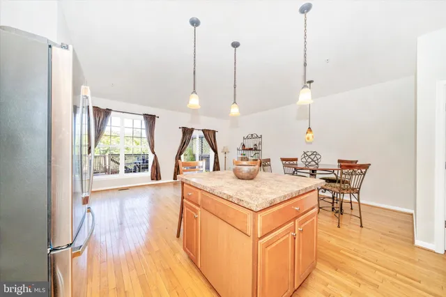 a kitchen with stainless steel appliances granite countertop a sink a stove and a wooden floors