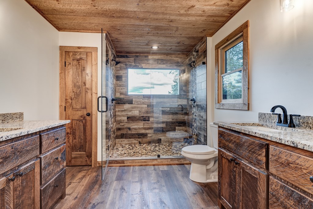 3448 Lickskillet Road Epworth, GA 30541 - Photo 15 of 71 a bathroom with a granite countertop sink a toilet a mirror and shower
