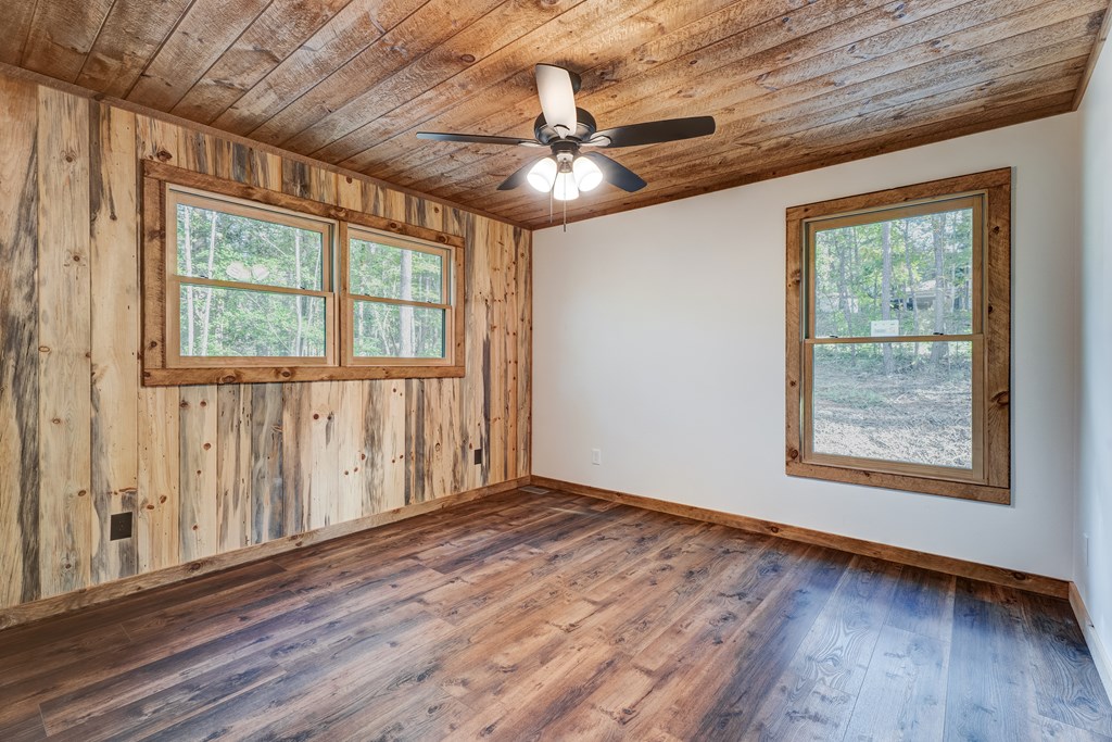 3448 Lickskillet Road Epworth, GA 30541 - Photo 21 of 71 an empty room with wooden floor chandelier fan and windows