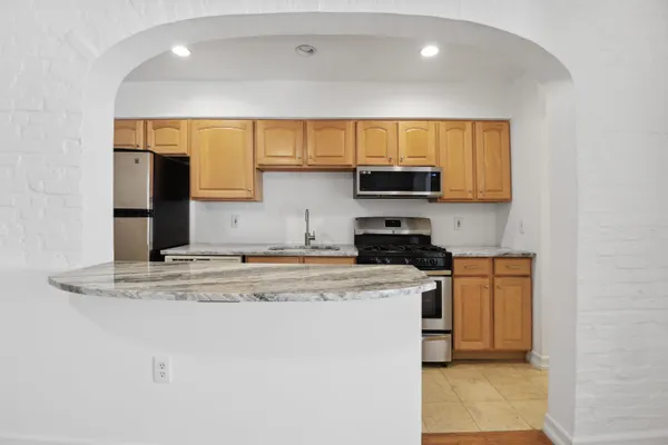 a kitchen with stainless steel appliances granite countertop a stove a sink and a microwave