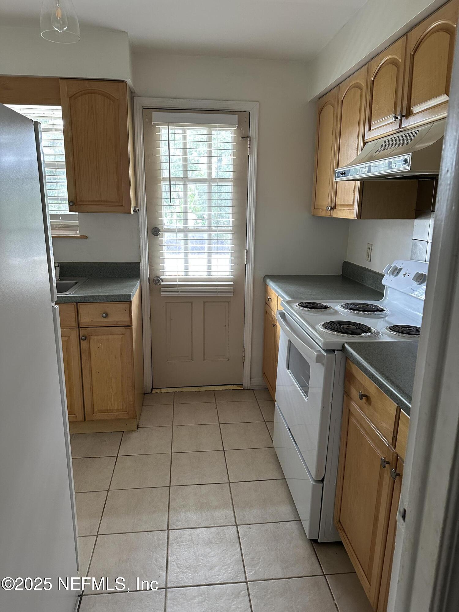 1756 El Prado Road, Unit 3 Jacksonville, FL 32216 - Photo 8 of 23 a kitchen with a stove a sink and a microwave