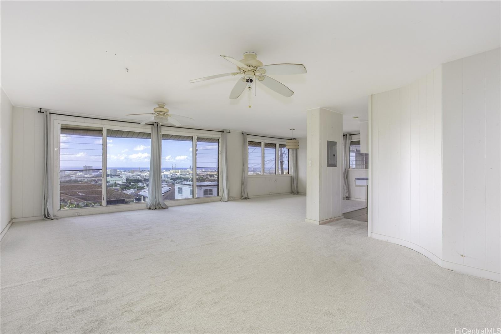 927 Lolena Street Honolulu, HI 96817 - Photo 3 of 12 an empty room with chandelier fan and windows