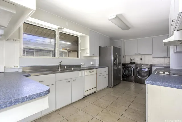 a kitchen with sink refrigerator and cabinets