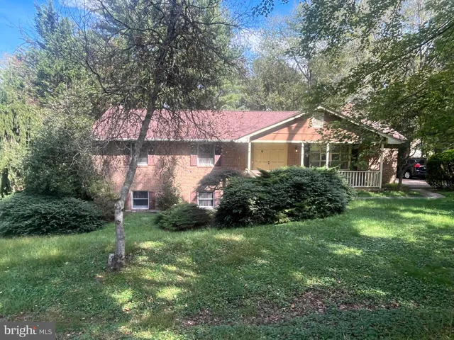 a front view of a house with a yard and trees