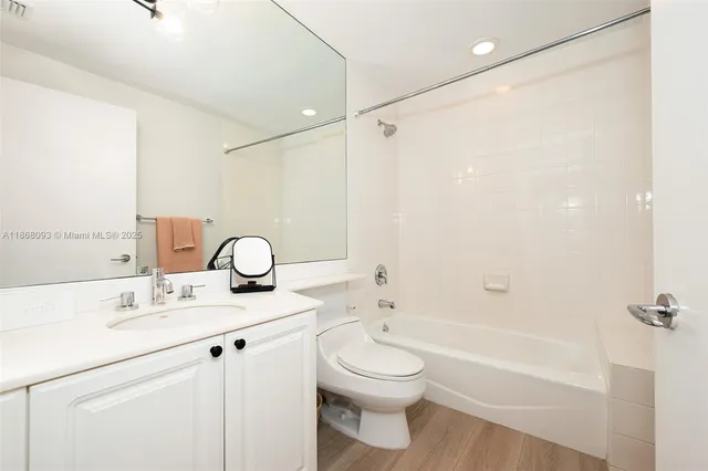 a bathroom with a granite countertop sink a toilet and a bathtub