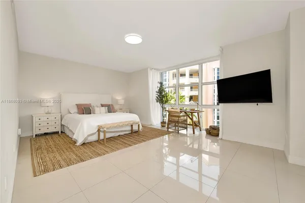 a bedroom with a bed and a flat screen tv