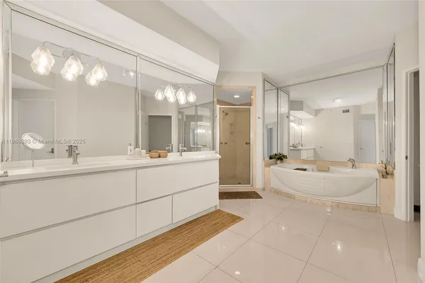 a bathroom with a double vanity sink a large mirror and shower