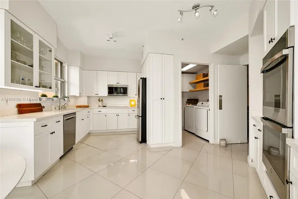 a kitchen with white cabinets and white appliances