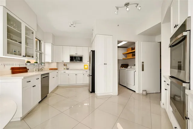 a kitchen with white cabinets and white appliances