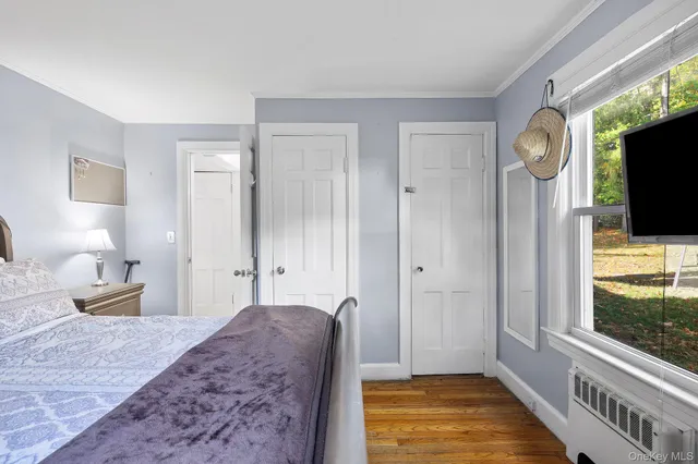 a bedroom with bed and flat tv screen on dresser