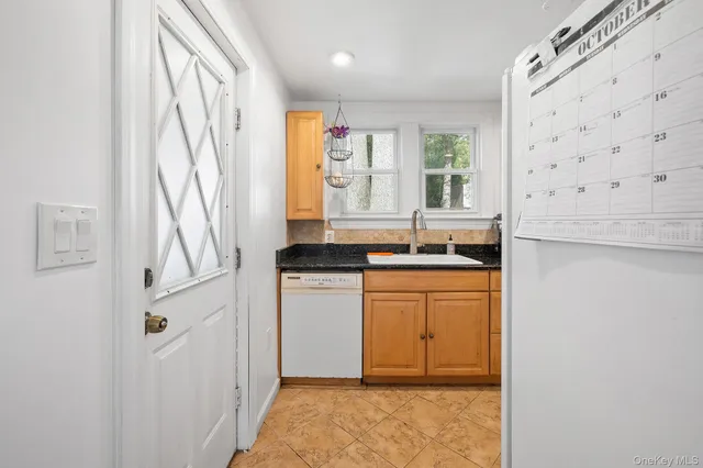 a bathroom with a granite countertop sink a mirror and a shower