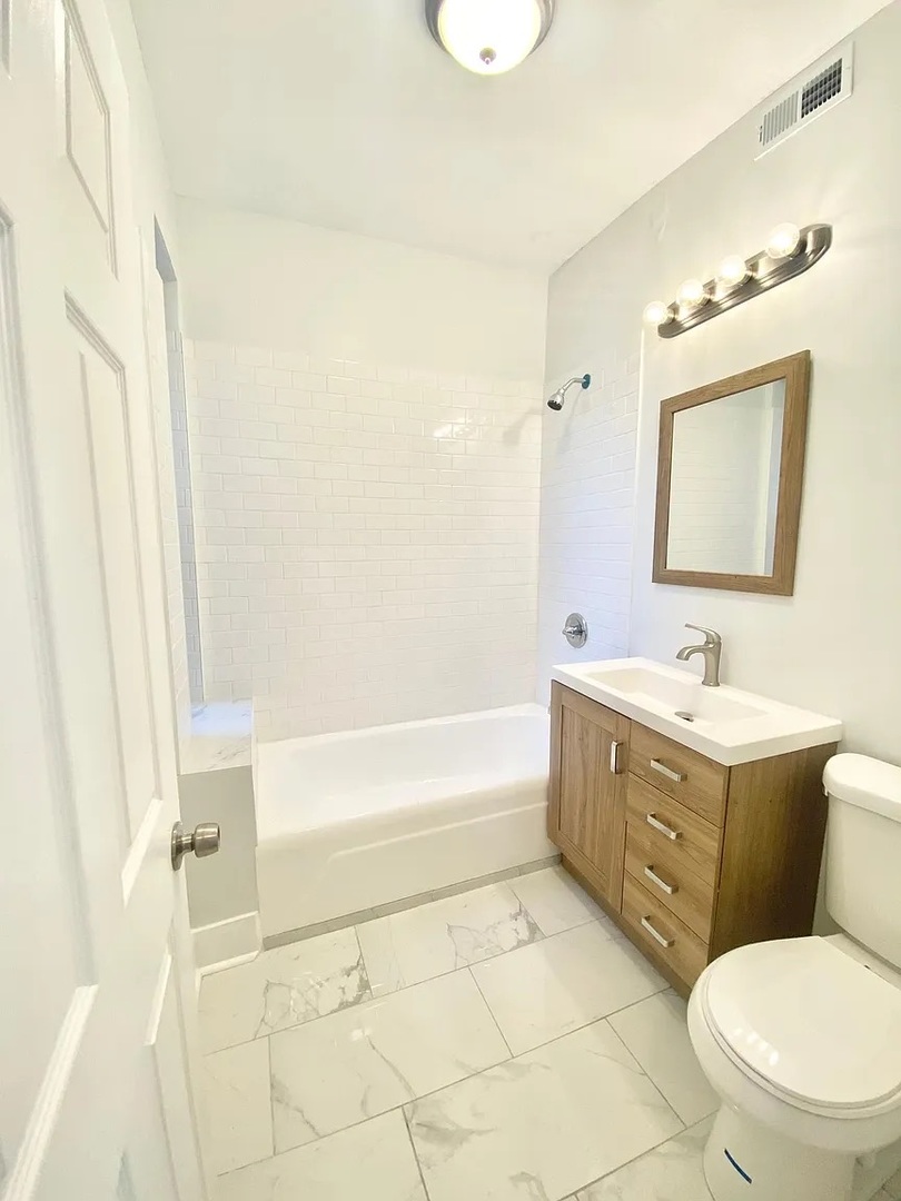 4100 West Henderson Street, Unit 1 Chicago, IL 60641 - Photo 6 of 8 a bathroom with a sink a toilet and bathtub