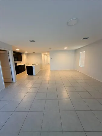 a view of a livingroom with an empty space and a window
