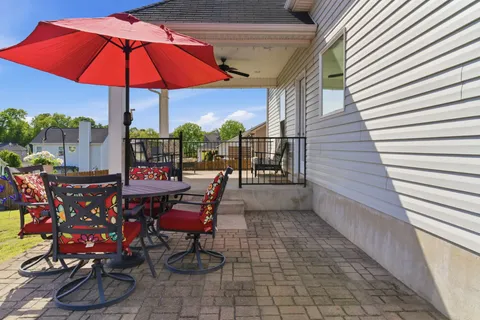 an outdoor sitting area with chairs and umbrella