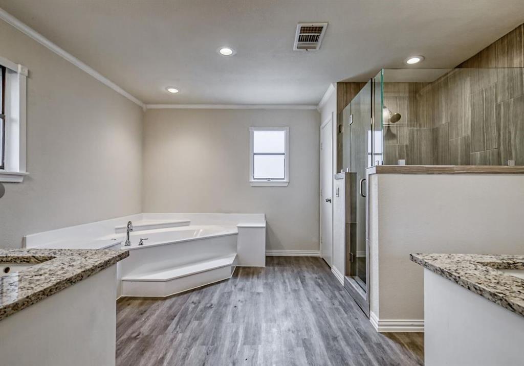 a bathroom with a granite countertop sink a toilet a mirror and shower