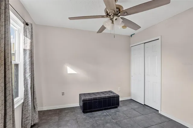 a room with a ceiling fan and a window