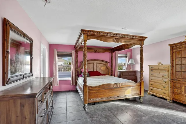 a bedroom with a bed and large windows