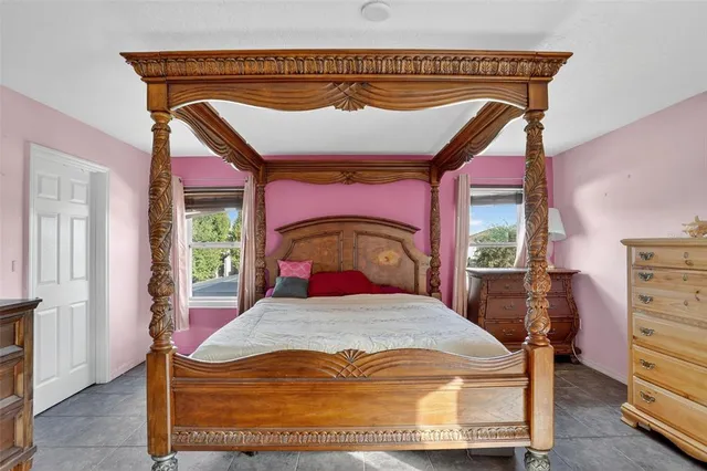 a bed sitting in a bedroom next to a window