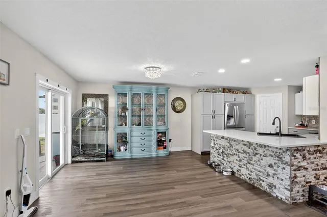 a view of a livingroom with wooden floor and kitchen space