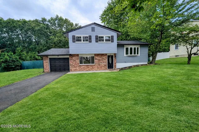a front view of a house with a garden and yard