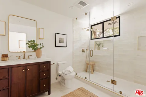 a bathroom with a toilet a sink and glass door