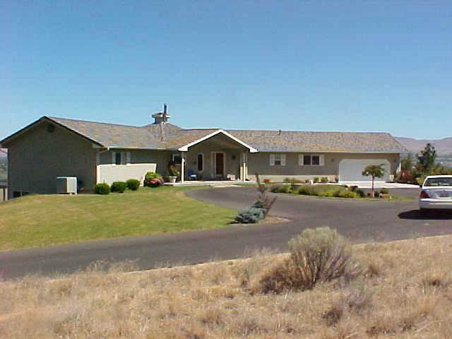 400 Alps Road Moxee, WA 98936 - Photo 1 of 9 a front view of a house with a garden and parking