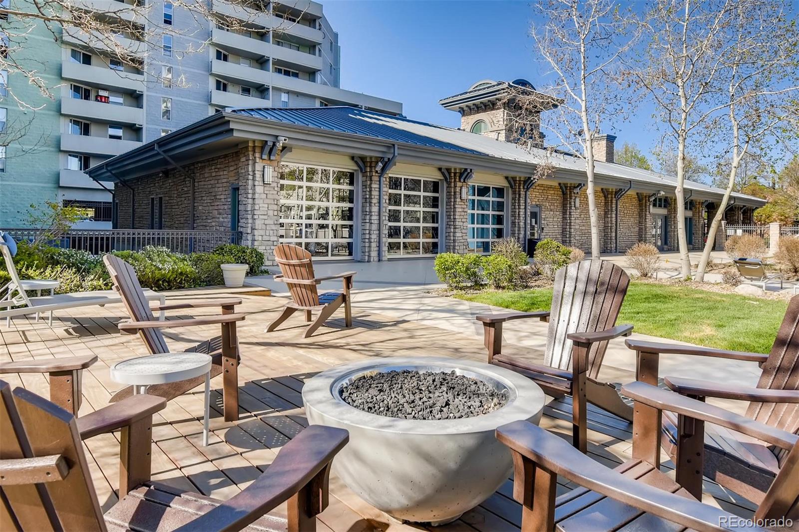1301 Speer Boulevard, Unit 403 Denver, CO 80204 - Photo 24 of 26 a view of a patio with table and chairs potted plants and a large tree