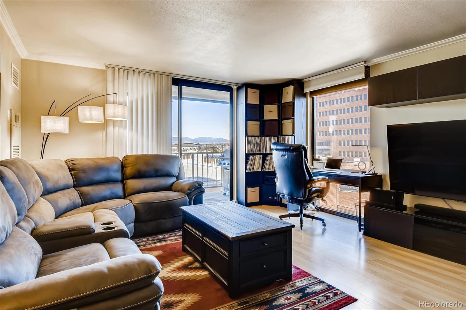 1301 Speer Boulevard, Unit 403 Denver, CO 80204 - Photo 3 of 26 a living room with furniture and a flat screen tv