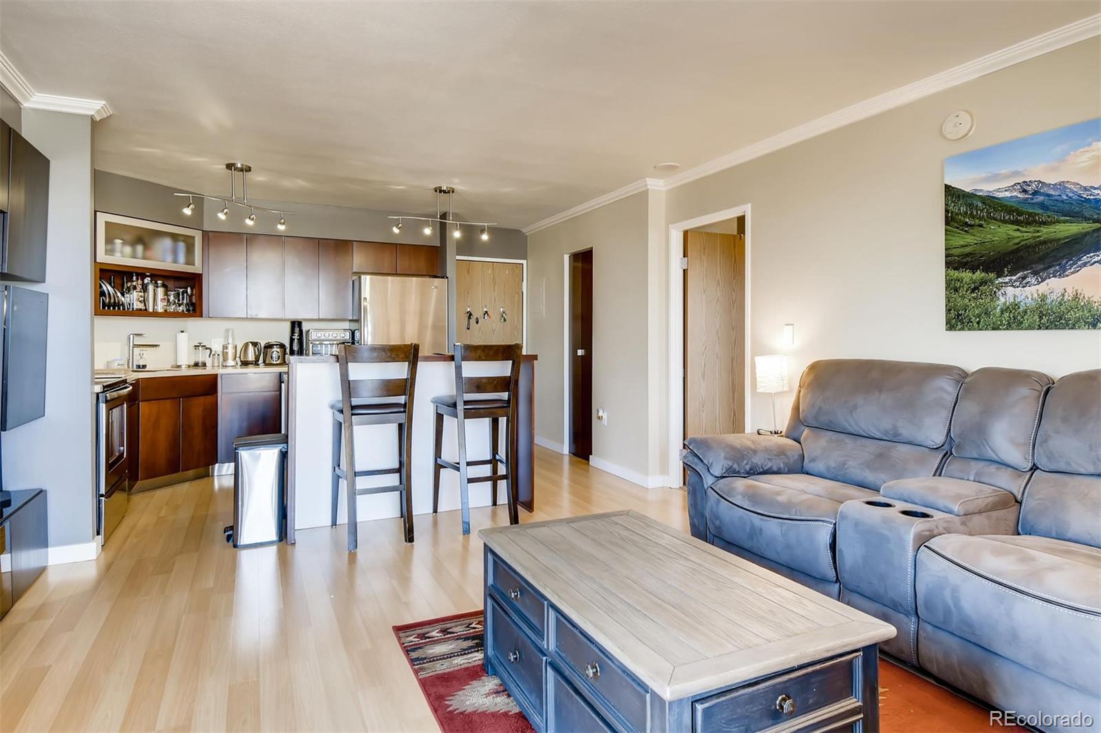 1301 Speer Boulevard, Unit 403 Denver, CO 80204 - Photo 4 of 26 a living room with stainless steel appliances kitchen island granite countertop furniture and a kitchen view