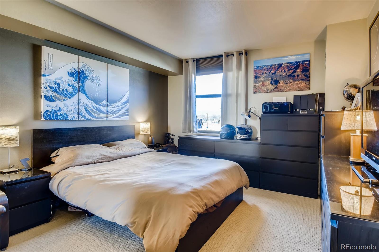 1301 Speer Boulevard, Unit 403 Denver, CO 80204 - Photo 7 of 26 a bedroom with a bed and a painting on the wall