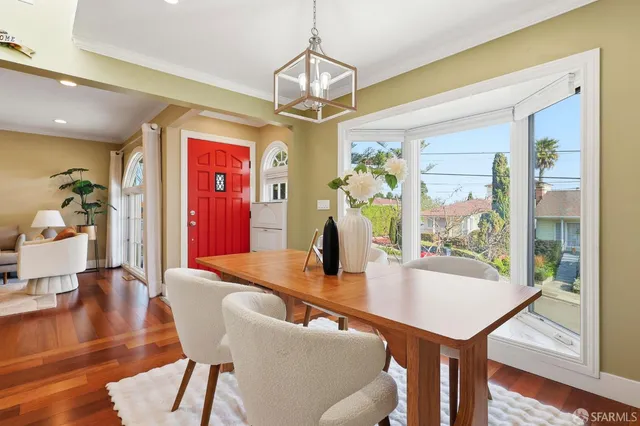 a dining room with furniture a chandelier and wooden floor