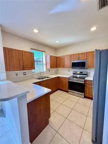 a kitchen with stainless steel appliances a stove a sink a microwave and a refrigerator