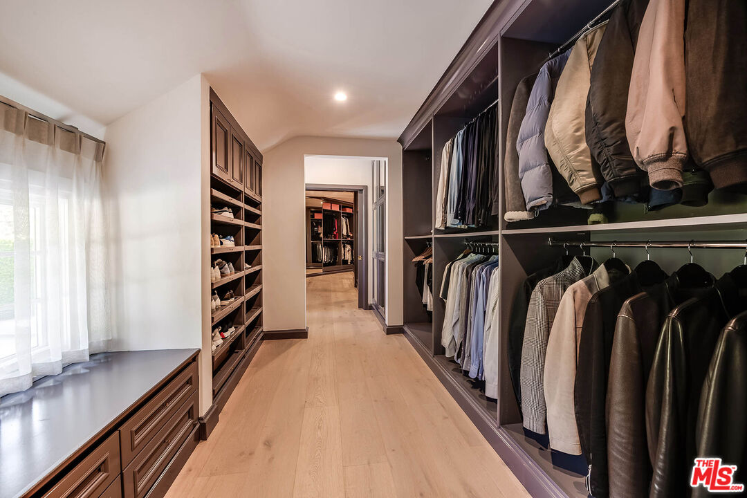 9551 Lime Orchard Road Beverly Hills, CA 90210 - Photo 21 of 27 a view of walk in closet with clothes and shoes