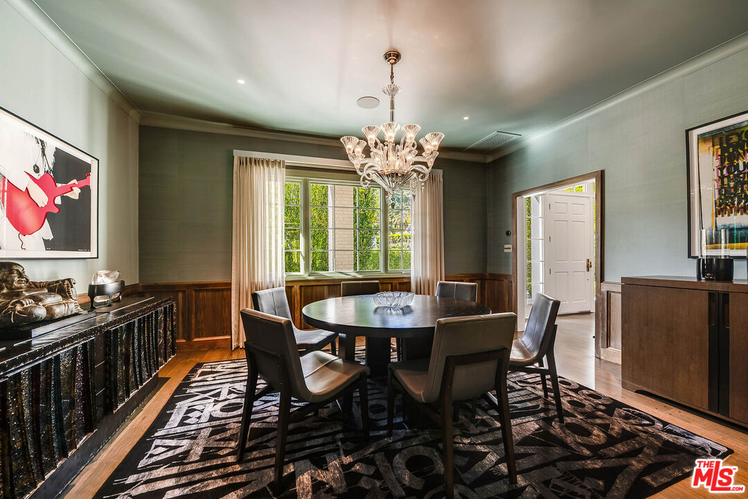9551 Lime Orchard Road Beverly Hills, CA 90210 - Photo 6 of 27 a dining room with wooden floor a chandelier a wooden table and chairs