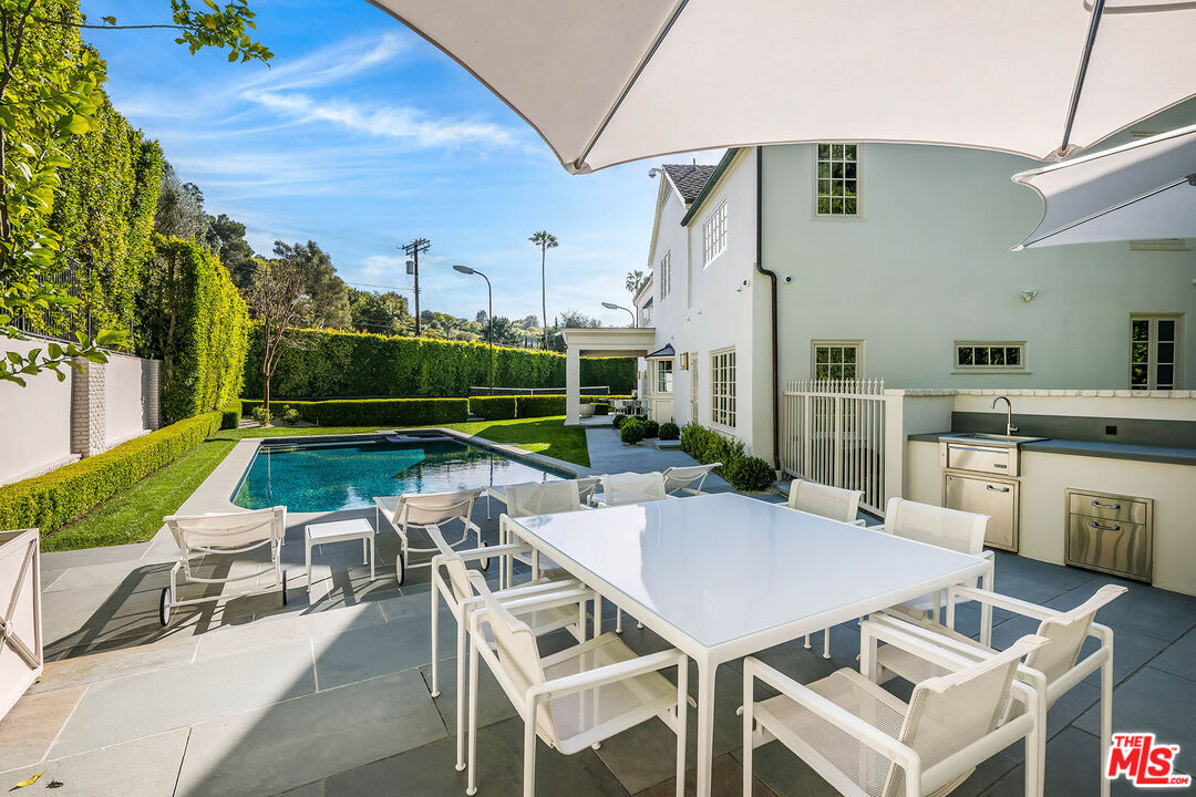 9551 Lime Orchard Road Beverly Hills, CA 90210 - Photo 9 of 27 a view of a patio with a dining table and chairs with a garden