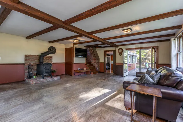 a living room with furniture a flat screen tv and a large window