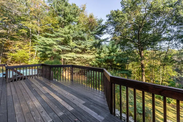 a balcony with wooden floor and yard in the back