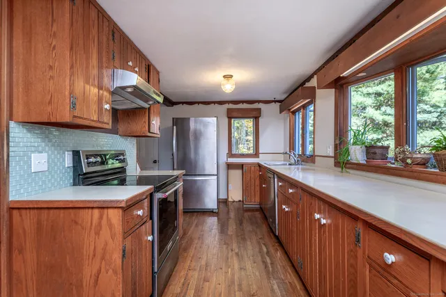a kitchen with stainless steel appliances granite countertop wooden cabinets a sink and a stove