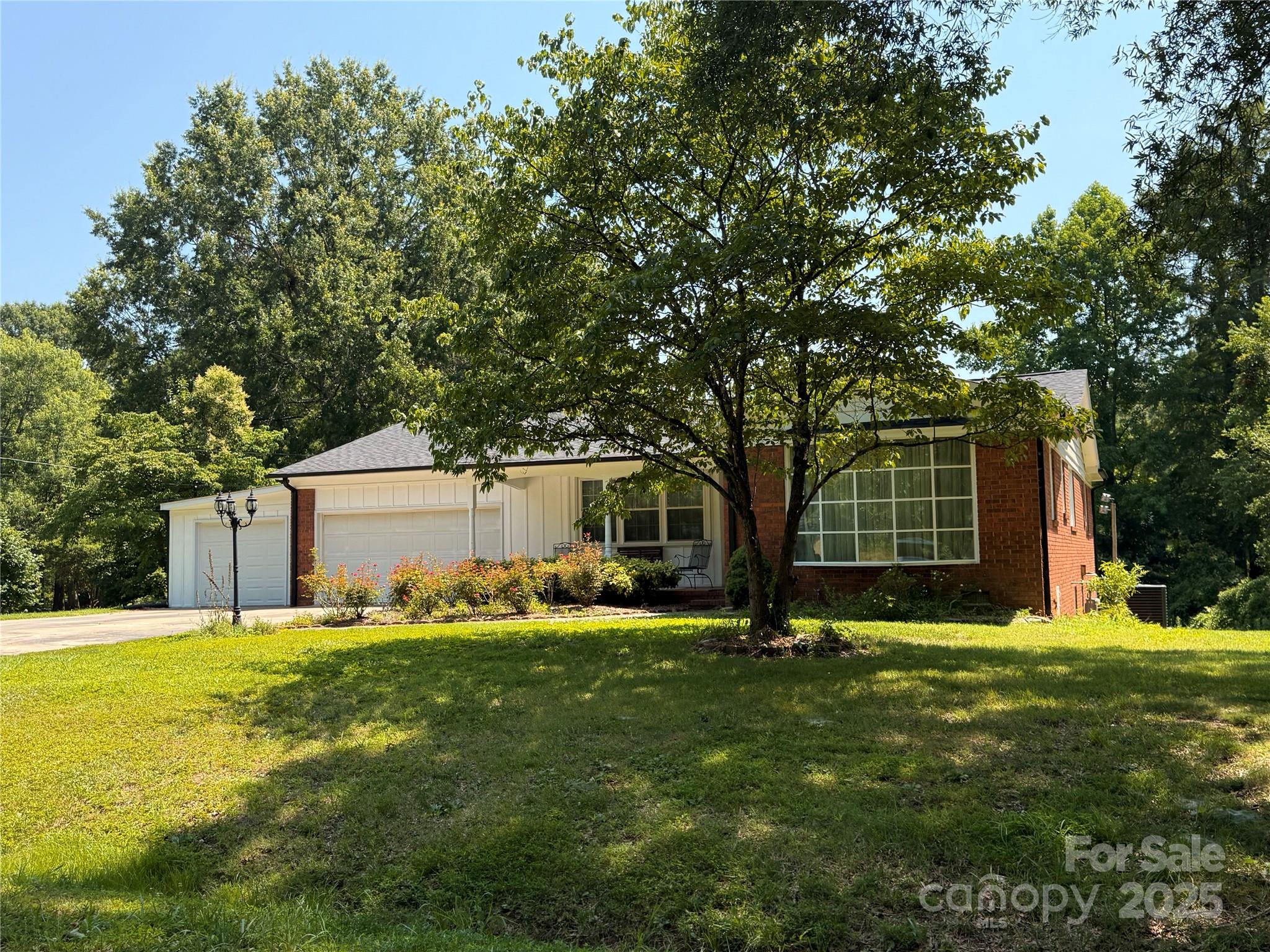 a view of a house with backyard and trees